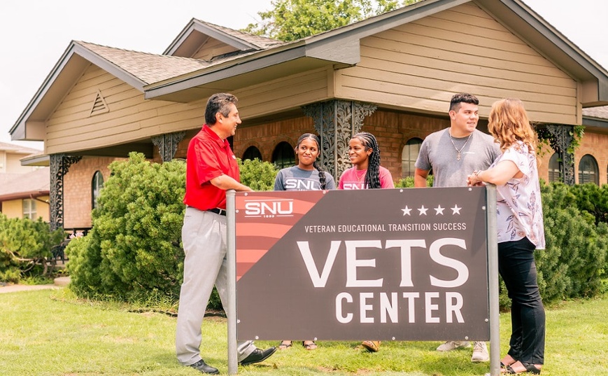 Family and SNU member standing in front of a Vets Center sign